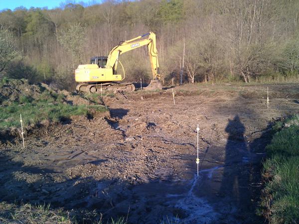 House site before foundation digging, with poles marking future corners of house.