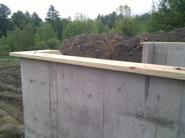 Detail of one corner of the foundation showing the sill plates we installed. The plates stick out 3.5 inches from the wall as in all FirstDay cottages.