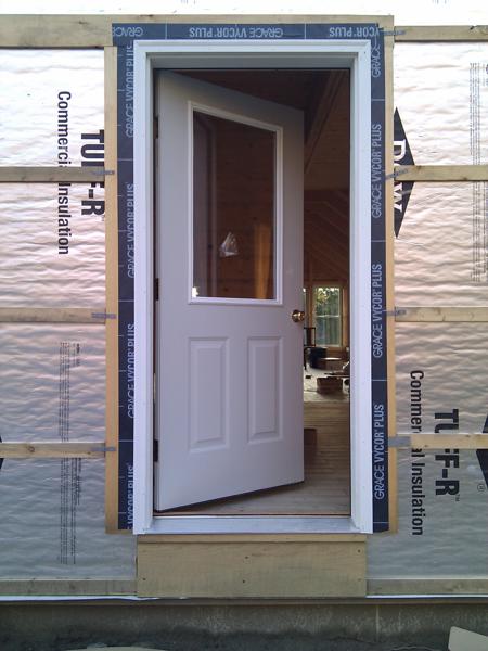 The four doors were fairly straightforward to install, but each one took about 2.5 hours to get shimmed and screwed into place.  Here you can see the pressure treated blocking I placed below the front door to support it.