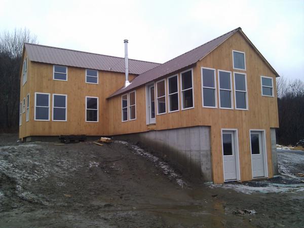 We finally finished the siding yesterday, after six weeks of working weekday mornings and weekends, and just before a spell of bad weather.  The last side we did was the east face of the one story section.  Its five windows, two doors, and triangular top made for complicated cut patterns.