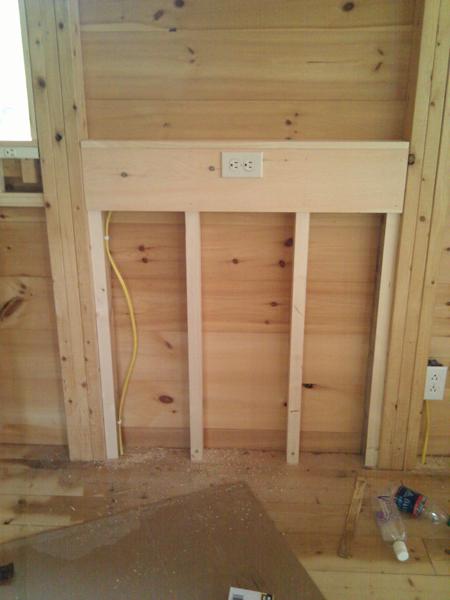 False wall for electrical outlets in pantry, the lower part of which will be hidden behind a counter.
