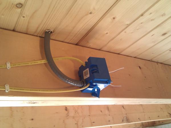 In the basement, the incoming Romex wires mate to outgoing THHN wires in a junction box, which then run up into the house through a flexible water-tight conduit.