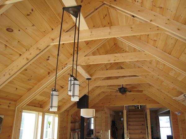 The ceiling lamps in the kitchen are powered by wires running in Wiremold metal raceways running up the posts and rafters.