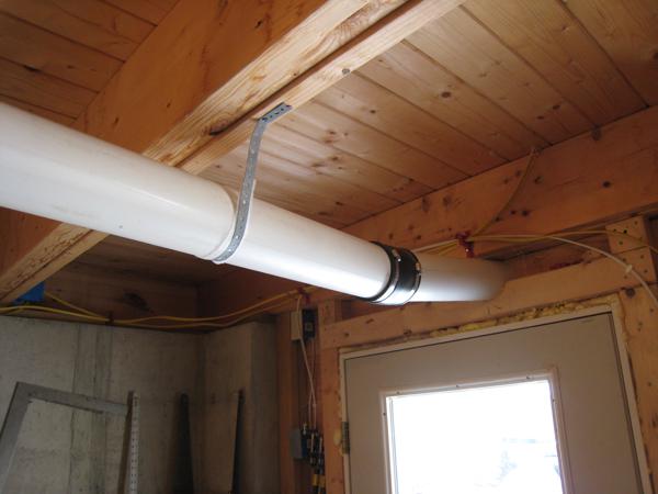 The radon pipe exits the basement through a hole above the door.
