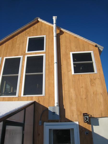 The radon pipe terminates with a rain cap 12 inches above the roof.