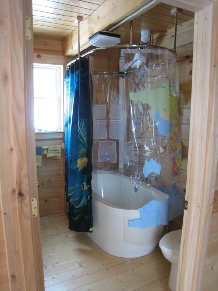 Bathtub in downstairs bathroom.  We didn't try to hide the plumbing leading to the upstairs half-bath; eventually we may paint the pipes, rather than try to hide them behind wooden boxes.