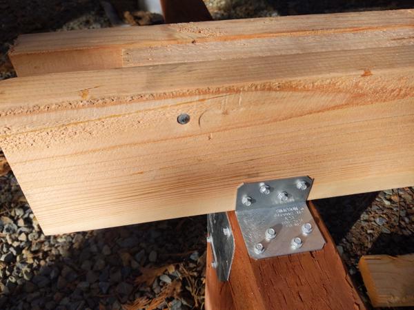Detail of angle bracket holding down a beam, instead of toenailing.