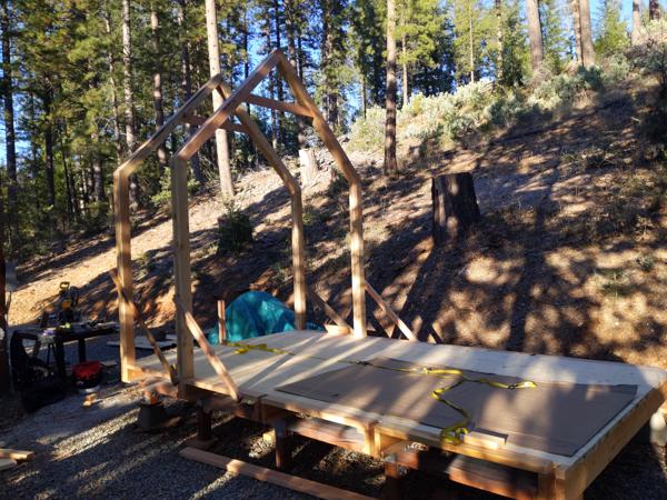 After the bent is vertical, the tongue of the post (the middle 2x4) drops into the slot in the floor beam.  Then I brace the bent and nail through the floor beam into the tongue.