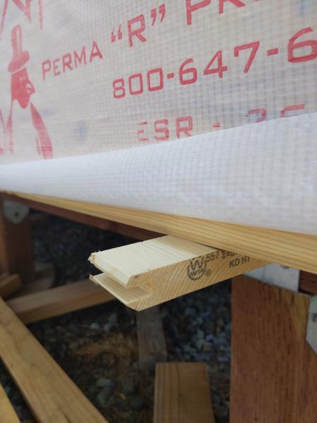 To support the lowest pieces of insulation while attaching them to the walls, I screwed little scraps of wood to the underside of the floor beams.