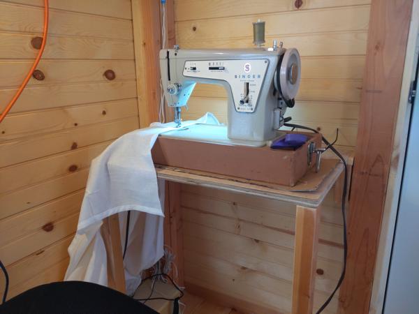 The final step was cutting and hemming curtains.  I used the laptop desk in the tiny house as the sewing station.